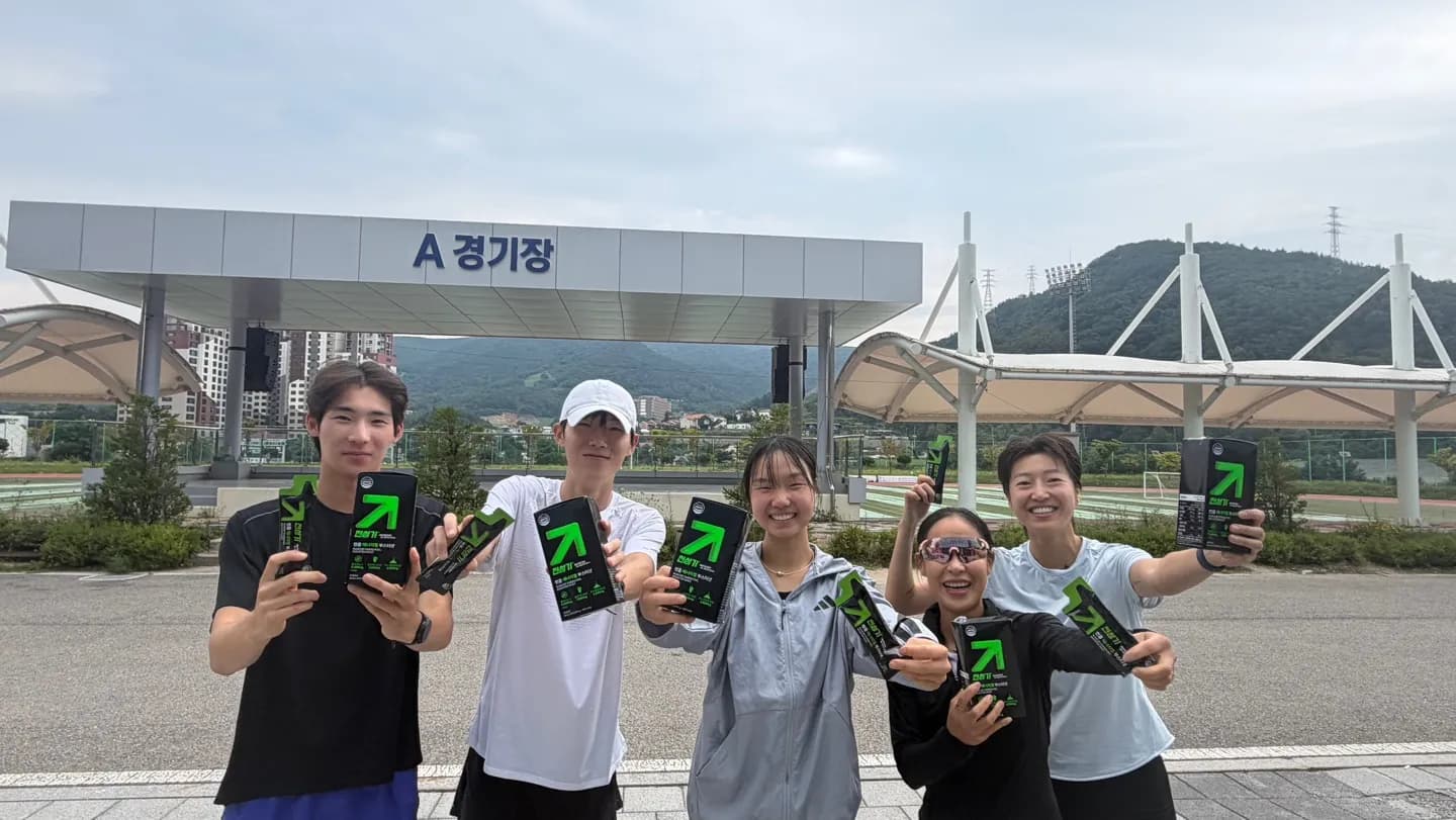 충주시청 육상팀 선수들이 경기장 앞에서 전성기 부스터샷을 들고 있는 사진